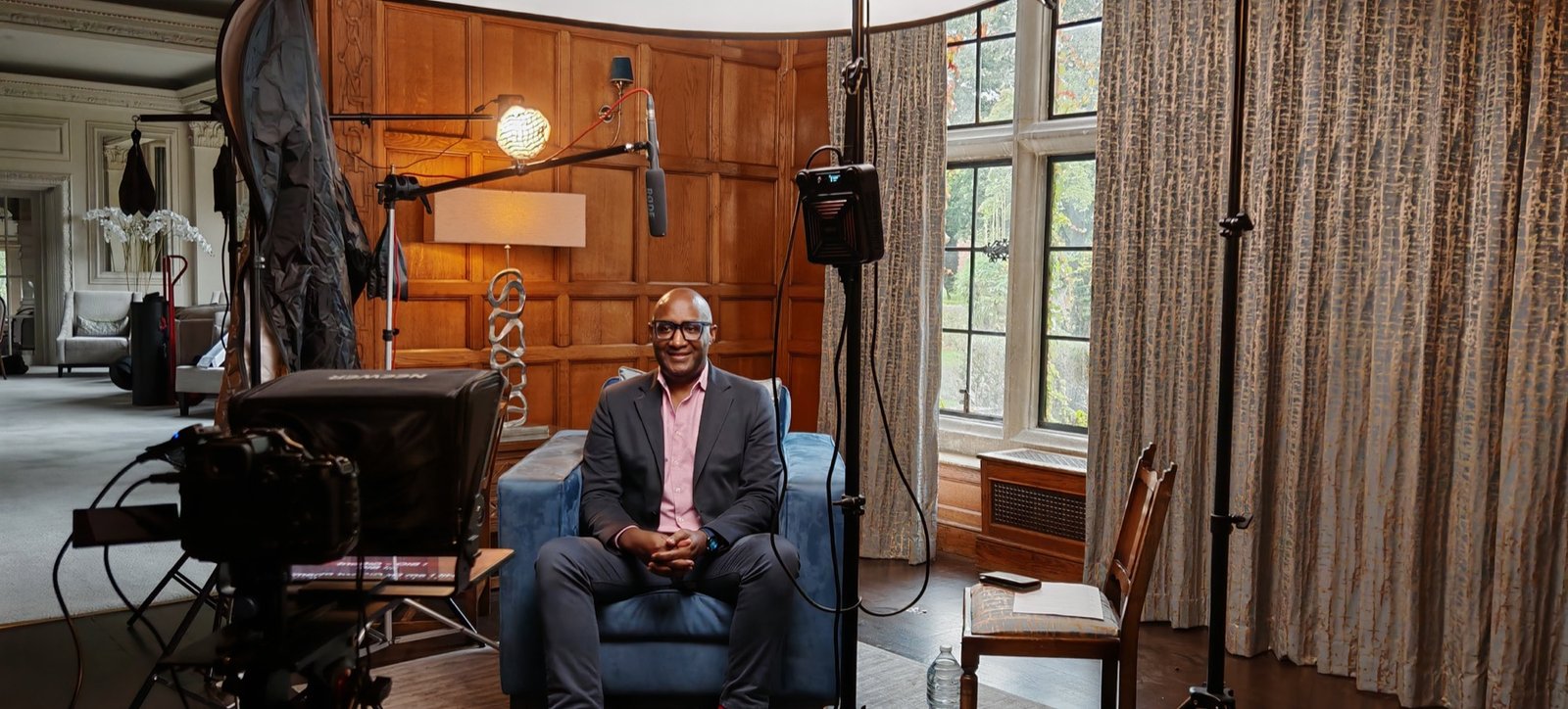 Interview filming setup in a wood-panelled room